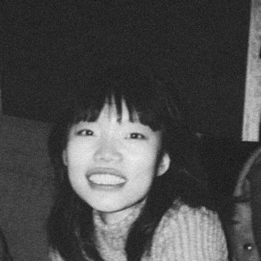 Black and white photo of a person with mid-length hair wearing a light sweater